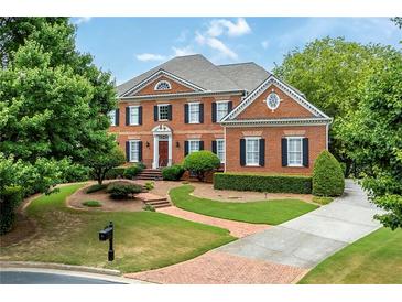 Beautiful brick two-story home with a well-manicured lawn, mature trees, and a circular driveway at 195 High Bluff Ct, Duluth, GA 30097