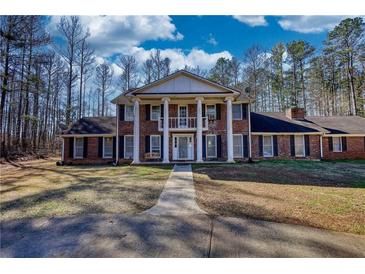 Traditional two-story brick home featuring a prominent portico and large front yard at 744 Hampton Locust Grove Rd, Hampton, GA 30228