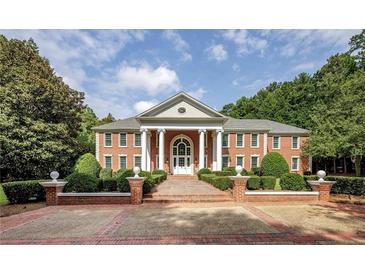 Stately brick home featuring a symmetrical design, grand columns, and manicured landscaping at 4500 Candacraig, Alpharetta, GA 30022