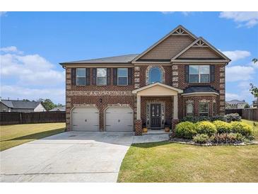 Charming brick two-story home boasts a well-manicured lawn and a two-car garage at 3815 Beaver Swamp Rd, Loganville, GA 30052