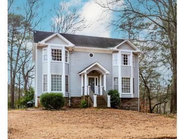 Charming two-story home features a quaint front porch, bay windows, and mature landscaping at 4900 Raquet Ct, Duluth, GA 30096