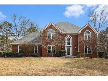 Charming two-story brick home features a well-manicured lawn and mature landscaping at 2331 Rabbit Farm Cir, Loganville, GA 30052