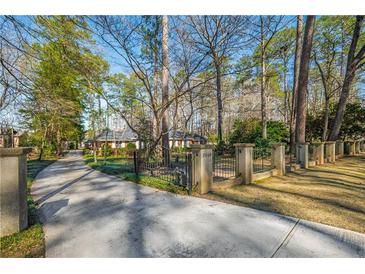 Charming single-story brick home with long drive, gated entrance and mature trees at 2506 Emerald Dr, Jonesboro, GA 30236