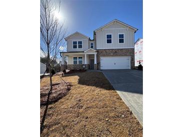 Charming two-story home featuring stone accents, a two-car garage, and a welcoming front porch at 135 Henley St, Canton, GA 30114