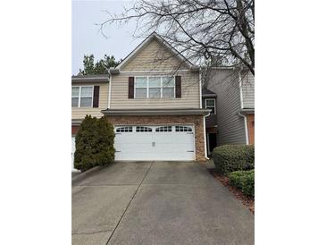 Two-story home featuring neutral siding, two car garage, and driveway at 1696 Tailmore Ln, Lawrenceville, GA 30043