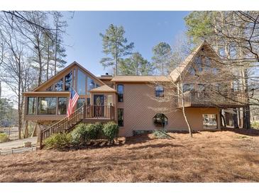 Charming home boasts large windows, a balcony, and a lush yard, blending architectural beauty with natural surroundings at 2731 Tritt Springs Ne Dr, Marietta, GA 30062