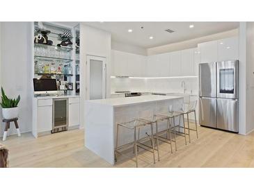 Modern kitchen featuring white cabinets, stainless steel appliances, a quartz countertop island, and a built-in bar area at 560 Dutch Valley Rd # 2313, Atlanta, GA 30324