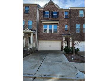Charming brick townhome with a two-car garage and a well-maintained front yard at 3765 Davis Cir, Duluth, GA 30096