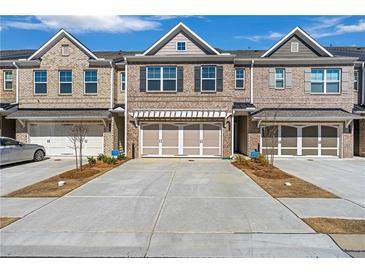 Charming brick townhome featuring a two-car garage and well-maintained landscaping at 2989 Chene Pl, Duluth, GA 30097