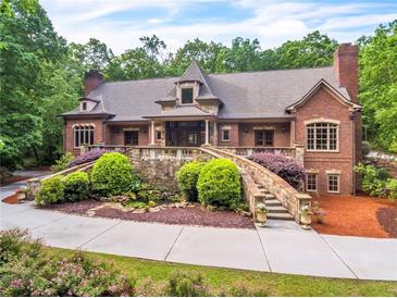 Majestic brick home with lush landscaping, a stone staircase, and a tranquil pond creates a serene outdoor setting at 4001 Pool Rd, Winston, GA 30187
