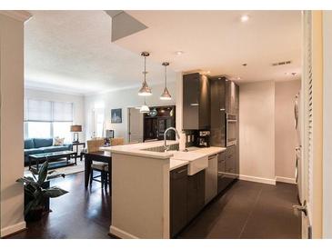 Open-concept kitchen with stainless steel appliances and breakfast bar, seamlessly connecting to the living area at 1101 Juniper Ne St # 721, Atlanta, GA 30309