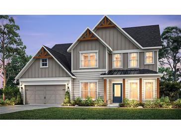 Charming two-story home boasts craftsman-style details, neutral tones, and lush front lawn at 1605 Wander Ml, Cumming, GA 30040