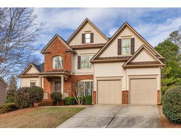 Charming two-story home featuring a blend of brick and siding, an attached two-car garage, and professional landscaping at 1837 Trilogy Park Dr, Hoschton, GA 30548