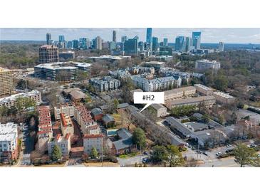 An aerial view of townhomes surrounded by trees, city skyline in the background, and easy access to nearby urban amenities at 3535 Roswell Ne Rd # H2, Atlanta, GA 30305