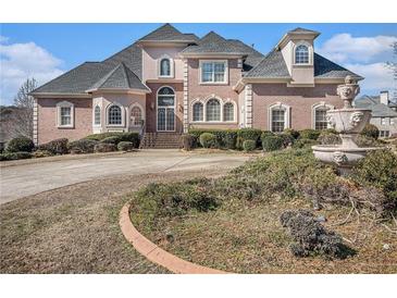 Elegant brick home with manicured landscaping, stately fountain, and a circular driveway at 461 Wynns Way, Atlanta, GA 30331