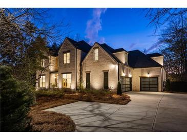 Stunning two-story brick home with a spacious driveway and attached two-car garage at 5060 Lake Forrest Dr, Atlanta, GA 30342