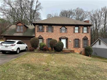Charming two-story brick home featuring manicured landscaping and a classic architectural design at 6420 Phillips Pl, Lithonia, GA 30058