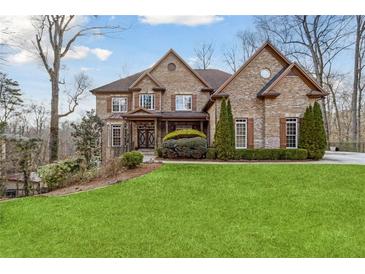 Beautiful two-story brick home with a well-manicured lawn and mature trees and shrubbery at 2353 Habersham Sw Dr, Marietta, GA 30064