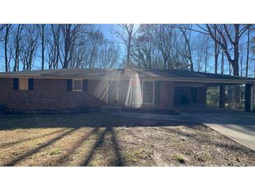 Charming single-story brick home with a covered carport and mature trees in a peaceful neighborhood at 533 Fayetteville Rd, Fairburn, GA 30213