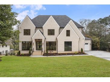 Charming two-story home with a manicured lawn, modern black window frames, and welcoming entryway at 4895 Lansbury Dr, Atlanta, GA 30342