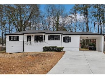 Charming single-story home featuring white painted brick, a covered front porch, and an attached carport at 5063 White Sw Blvd, Mableton, GA 30126