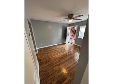 Open living room with hardwood floors, ceiling fan, and an open door leading to the outside at 571 Formwalt Sw St # 7, Atlanta, GA 30312