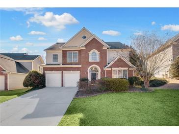 Charming two-story brick home with a well-manicured lawn and attached two-car garage at 5466 Vinings Lake Way, Mableton, GA 30126