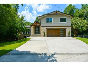 Beautifully landscaped home boasts a modern facade, stone accents, and a spacious driveway at 2116 Strasburg Ct, Dunwoody, GA 30338