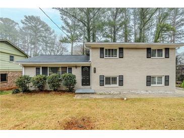 Charming two-story home with a classic brick exterior, complemented by black shutters and lush front yard landscaping at 2916 Lloyd Rd, Decatur, GA 30034
