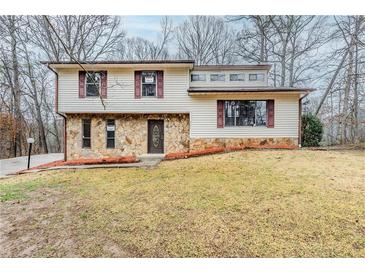 Charming home with stone accents and shuttered windows surrounded by a beautiful wooded landscape at 3998 Chimney Ridge Dr, Ellenwood, GA 30294