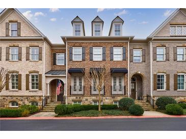Charming brick townhome with black awnings, dormer windows, and manicured landscaping at 2368 Saint Davids Nw Sq # 4, Kennesaw, GA 30152
