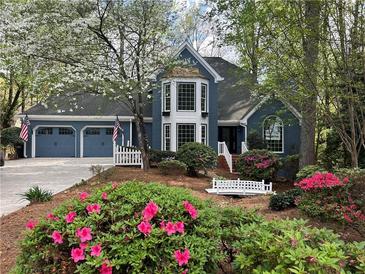 Charming blue two-story home with landscaped yard, two car garage, and blooming azaleas at 3017 Lana Ln, Marietta, GA 30066