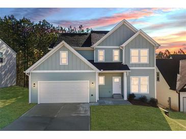 Charming two-story home boasts a two-car garage, classic architectural style, and verdant landscaping at 3200 Tackett Rd, Douglasville, GA 30135