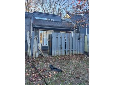 Exterior of home featuring a small gated yard space with damaged fence in need of repair at 4707 Mariners Way, Stone Mountain, GA 30083