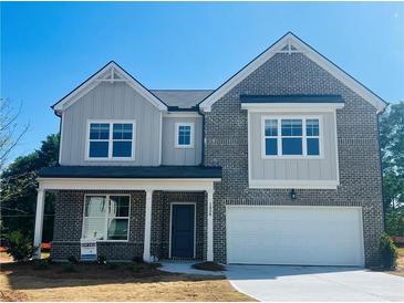Charming two-story home with a two-car garage, brick facade, and a beautifully landscaped front yard at 1856 Kingsmere Run Dr, Loganville, GA 30052