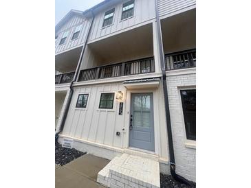 Charming townhome entrance with a light blue door and brick accents on a cloudy day at 1313 Breezy Street # 131, Atlanta, GA 30315