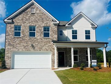 Charming two-story home with a brick facade, white siding, and a well-maintained lawn at 1847 Kingsmere Run Dr, Loganville, GA 30052