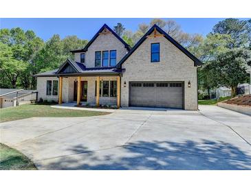 Stunning two-story home with a light brick facade, dark trim, and a spacious driveway and lush landscaping at 270 New Hope Rd, Lawrenceville, GA 30046