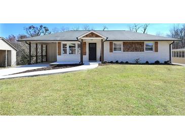 Charming renovated ranch-style home featuring white painted brick, a covered parking area and a well-manicured lawn at 900 King Rd, Jonesboro, GA 30236