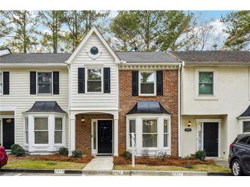 Charming townhome featuring a brick facade, black shutters, and a well-manicured lawn at 2977 Heritage Villas Dr, Lithonia, GA 30038
