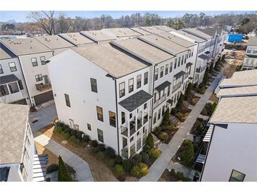 Stylish townhouse exteriors featuring balconies, manicured landscaping, and modern design elements at 1756 Morningtide Ne Ln, Atlanta, GA 30324