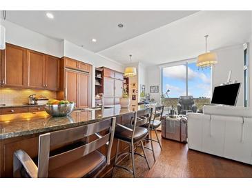 Bright kitchen features dark wood cabinetry, granite counters, a large island with seating, and views at 3630 Peachtree Ne Rd # 1809, Atlanta, GA 30326