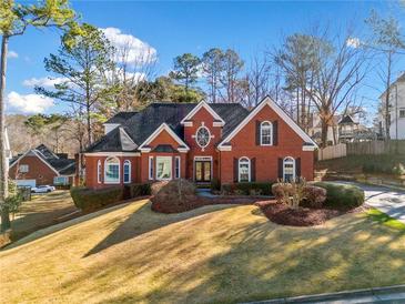 A beautifully designed red brick home with a well-maintained lawn and mature landscaping at 110 Shadow Creek Chase, Alpharetta, GA 30022