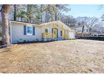 Charming ranch home with yellow porch railing, light gray brick, and cheerful yellow front door at 6058 Ledgewood Dr, Forest Park, GA 30297