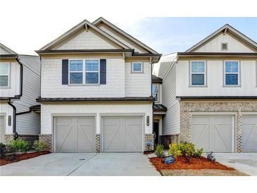 Charming townhome featuring a two-car garage, and beautifully landscaped front yard at 4118 Haleston Rd, Duluth, GA 30097