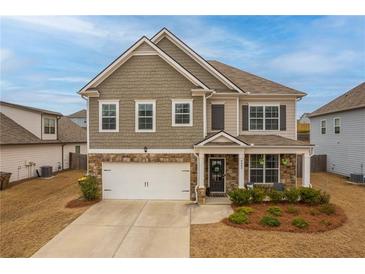 Charming two-story home featuring stone accents, a two-car garage, and a well-maintained front lawn at 4480 Sunflower Cir, Cumming, GA 30040