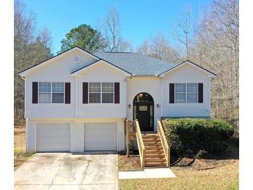 Charming two-story home with a well-maintained lawn, garage, and inviting front entry, showcasing curb appeal at 305 Long Creek Dr, Covington, GA 30016