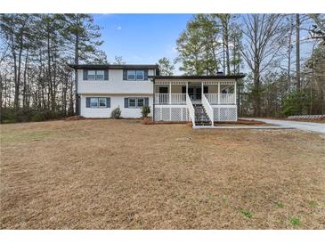 Charming two-story home with a cozy porch, and well maintained front yard at 6715 Green Acres Dr, Douglasville, GA 30135