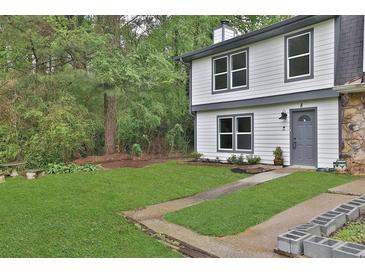 Charming two-story home featuring a well-manicured lawn and fresh, modern paint at 8 Pine Canyon Sw Dr, Atlanta, GA 30331