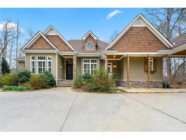 Charming home featuring stone accents, covered porch, and mature landscaping with circular driveway at 30 Crolley Ln, White, GA 30184